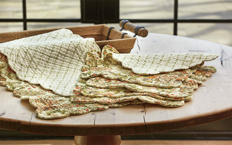 Floral quilted placemats and table runners on round wood table