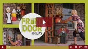 front porch with large wooden welcome sign, wooden turkey, pumpkins, fall flowers and gourds