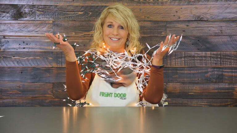 woman sitting at table with tangled Christmas lights