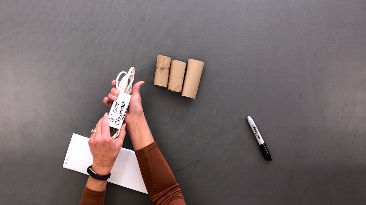 woman using cardboard tubes to store extension cords