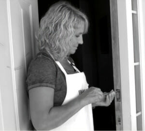 woman fixing a door lock with a screwdriver