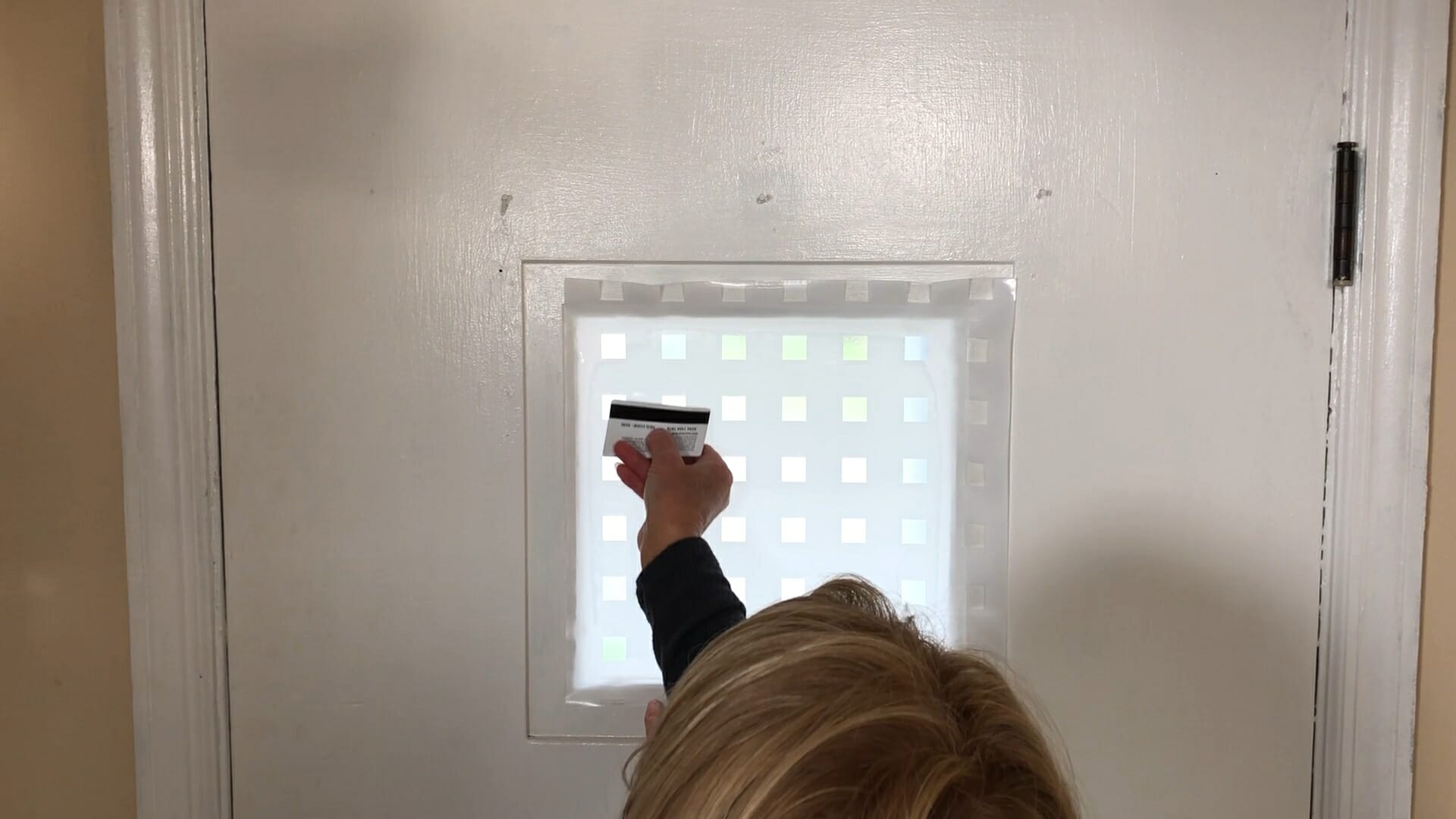 woman using a credit card to smooth out privacy film to assure no bubbles