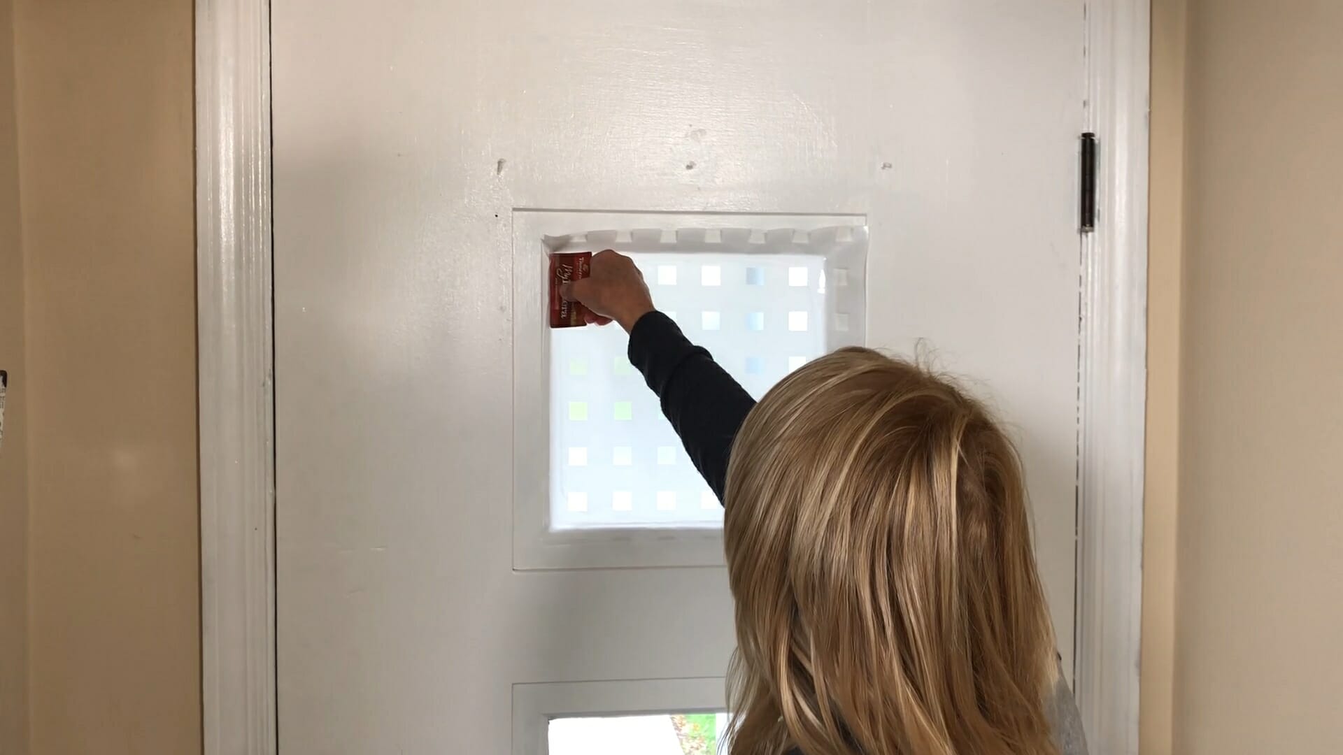 woman using credit card in corner of window to assure a smooth edge to privacy film