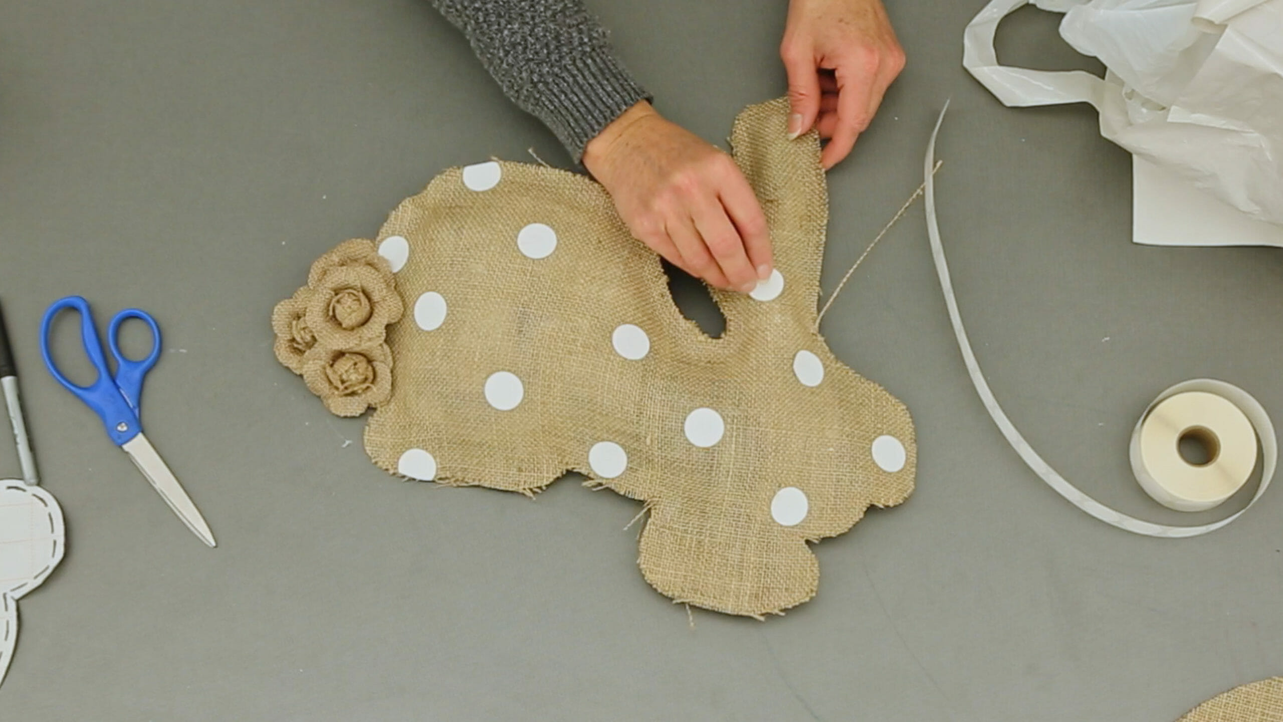 woman putting polka dots on burlap bunny