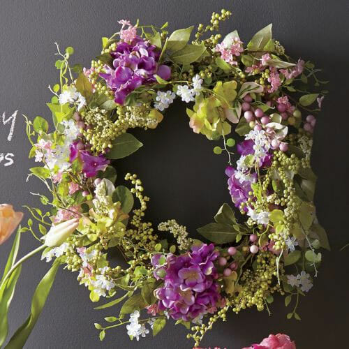 A round wreath with magenta hydrangeas, white flowers, and lime hydrangea, berries and leaves.