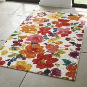 A bright multicolor floral kitchen rug on a white tile floor. 
