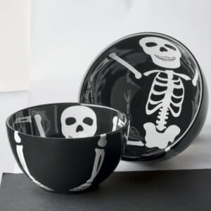 A set of two black bowls with a white skeleton design inside and continued to the outer side.