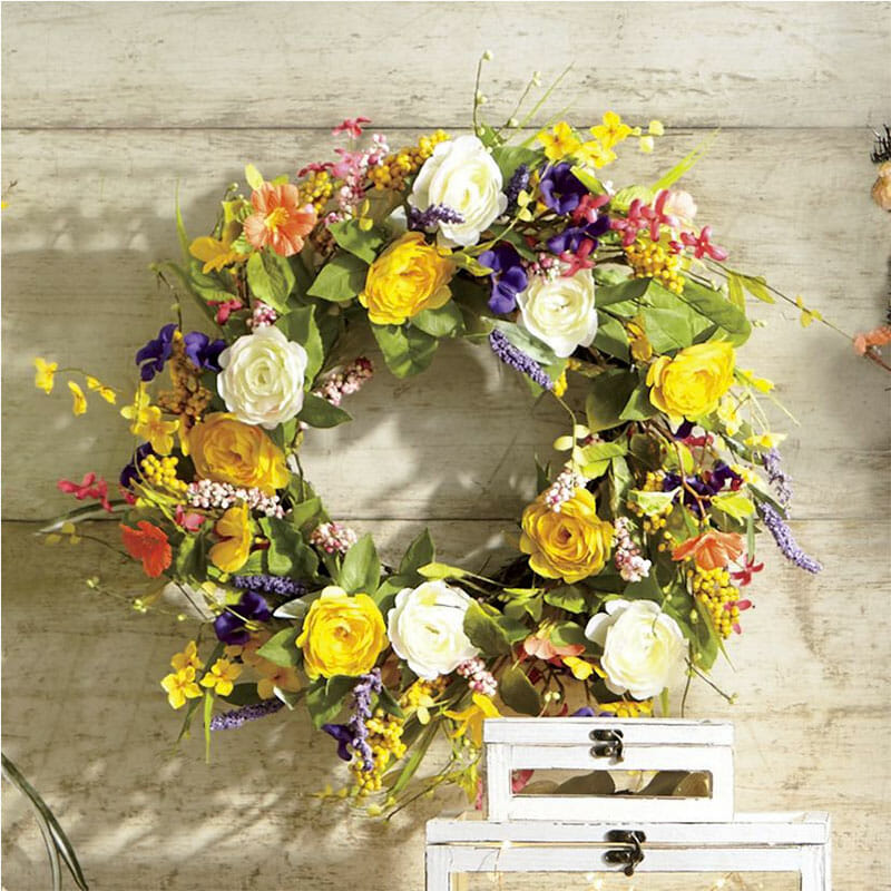 A multicolor round wreath with white and yellow roses, and other berries and flowers.