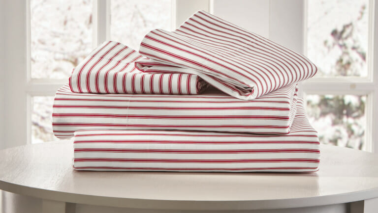 Red and white stripe sheet set on a white round table