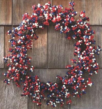 Faux red, white, and blue berries on a round grapevine wreath.