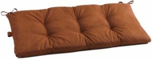 A brown tufted bench cushion with ties.