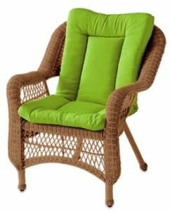 A green seat and back cushion on a brown wicker chair.