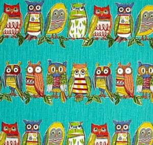 Owl Hoot – A fabric swatch with rows of multicolor cartoon owls on a teal background.