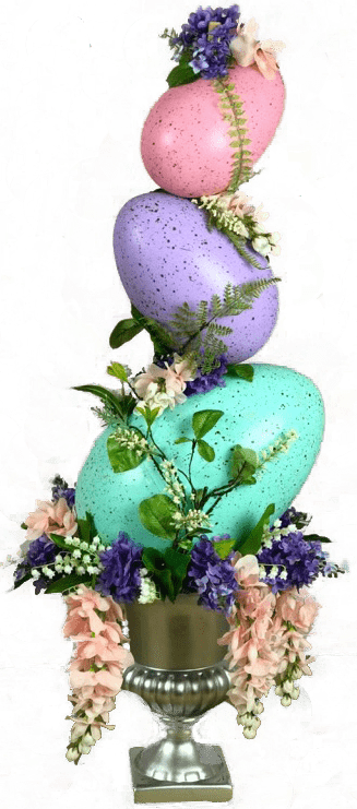 An egg topiary of three colored eggs stacked on a silver vase, adorned with pink and purple Spring flowers.