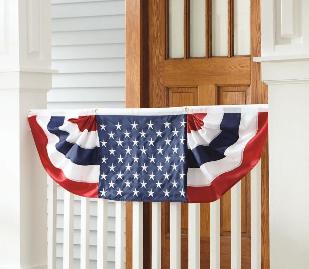 Patriotic bunting on a white porch banister.