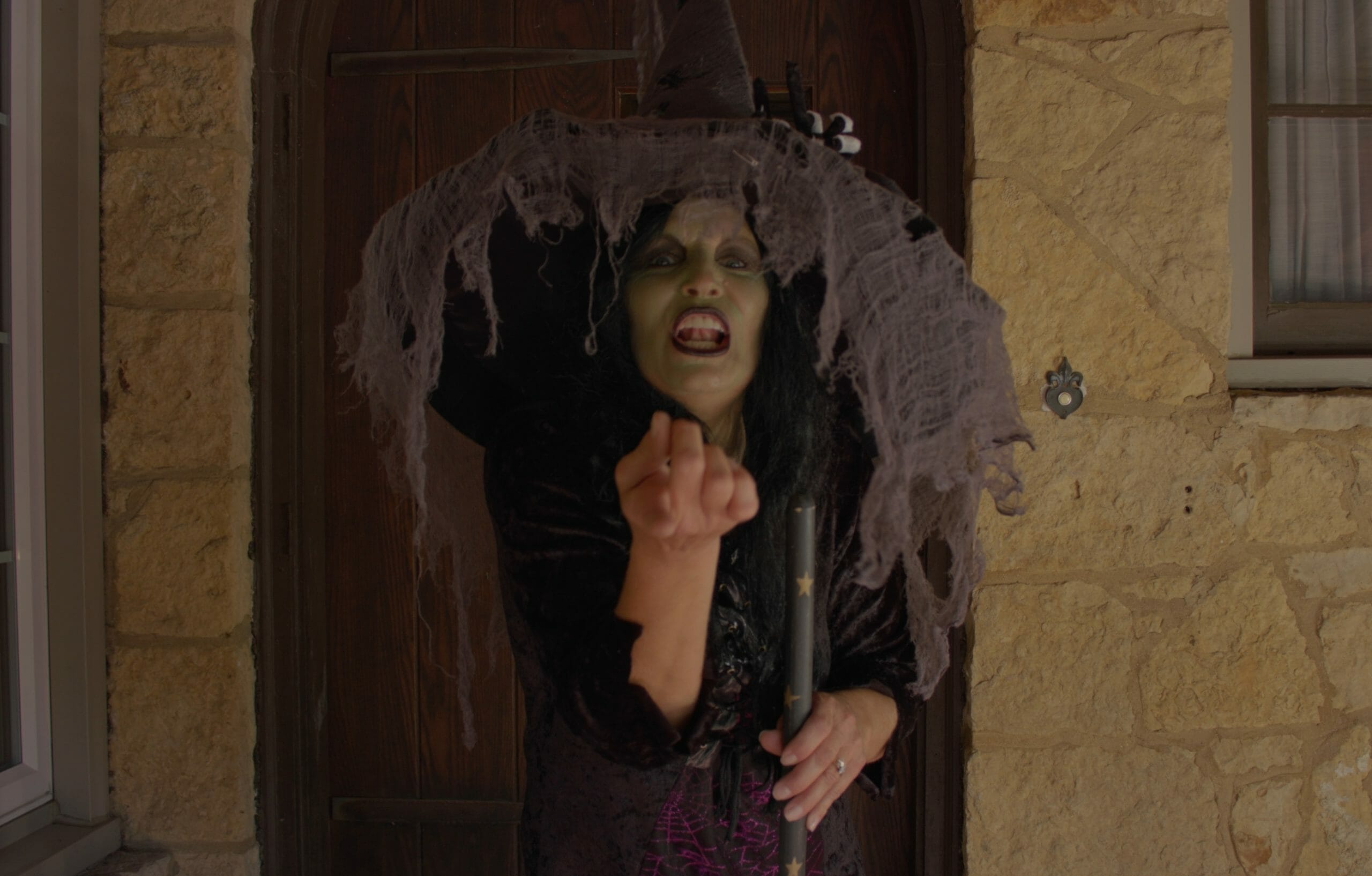 woman dressed as a witch beckoning you to come near