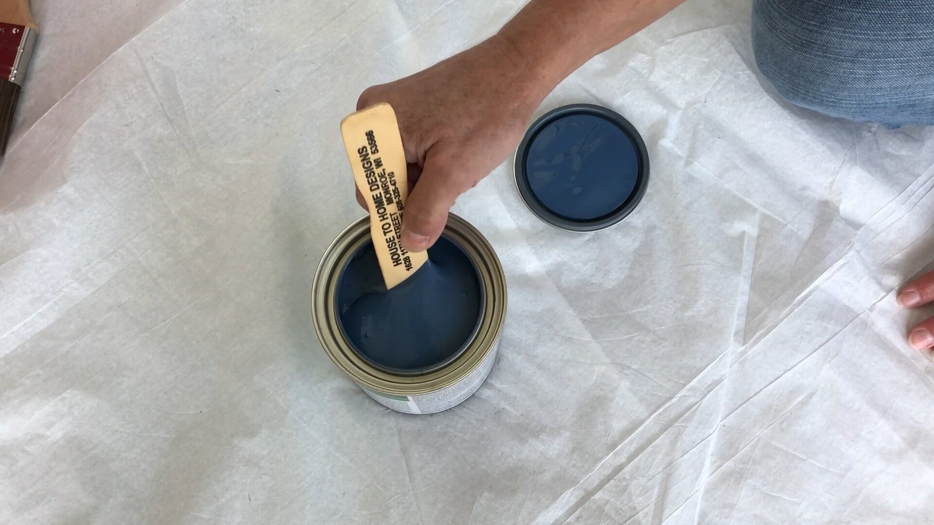 woman mixing country blue paint with paint stick