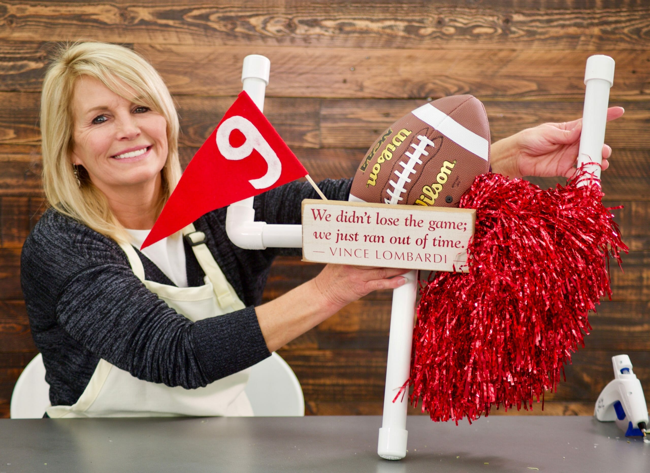 woman with a football themed wreath that includes football pom poms flag and goal post made from pvc