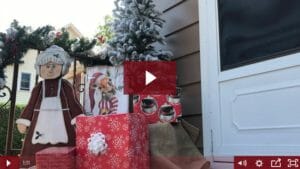 outside step with wooden Mrs. Claus figure, wrapped presents, and small flocked tree