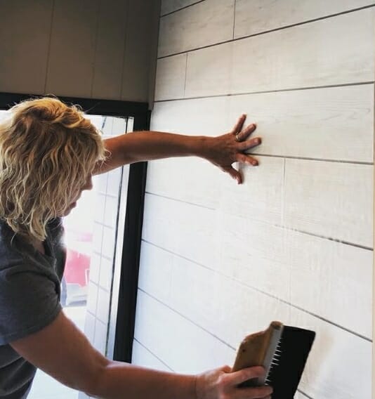 woman brushing a wall off