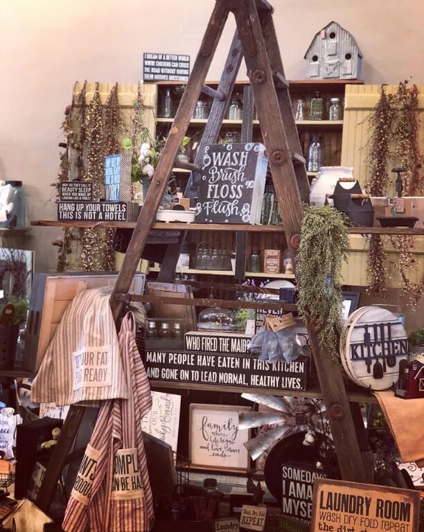 a tall wooden step ladder in a Country store is stocked with country décor for sale