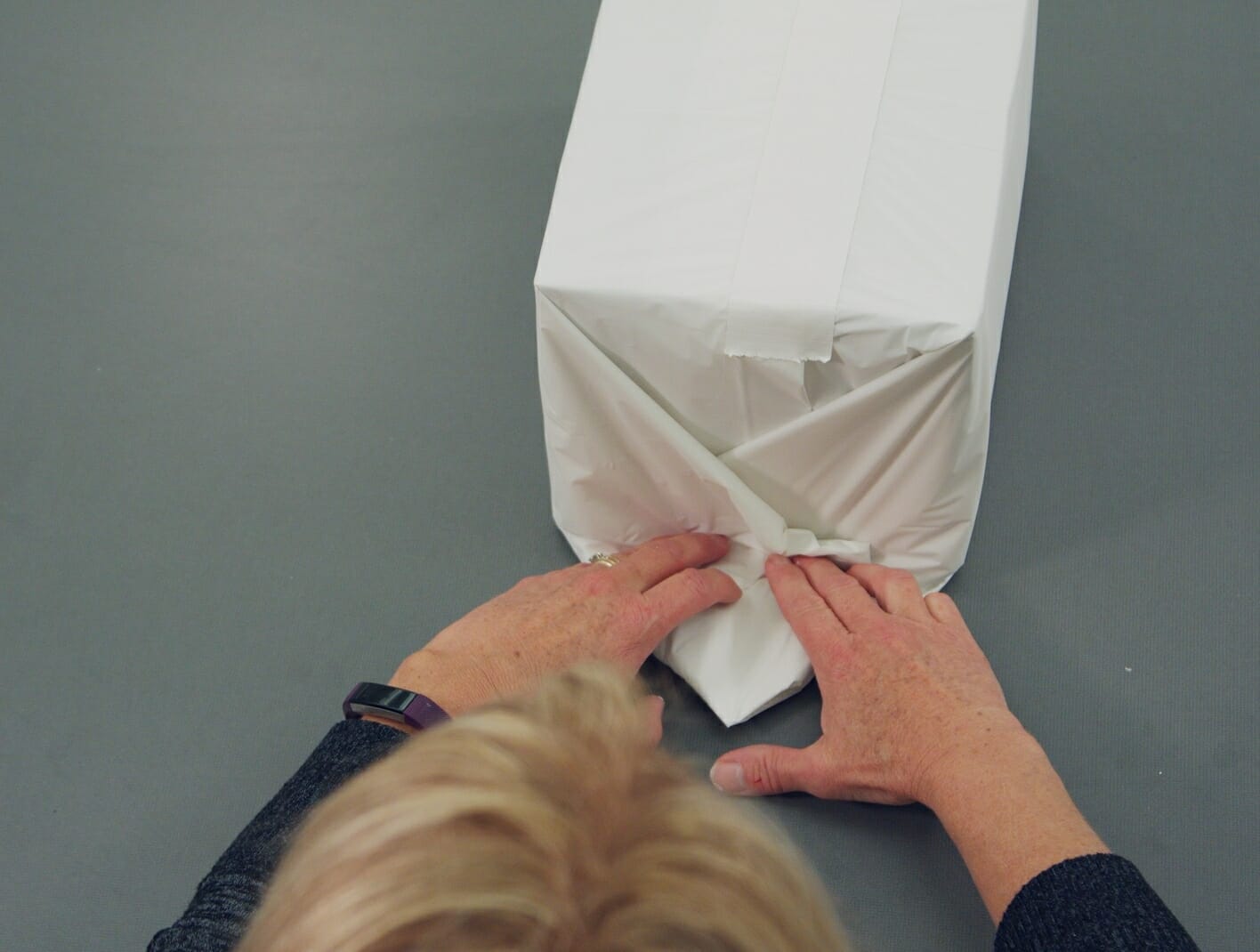 woman wrapping white paper around box