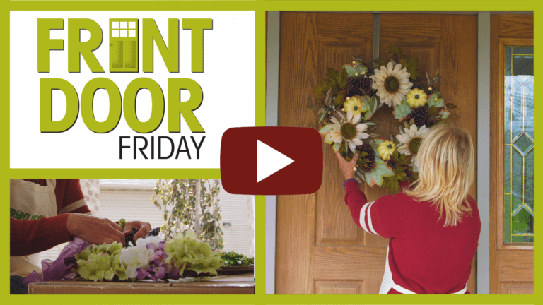 woman hanging sunflower wreath on front door for a fall décor theme