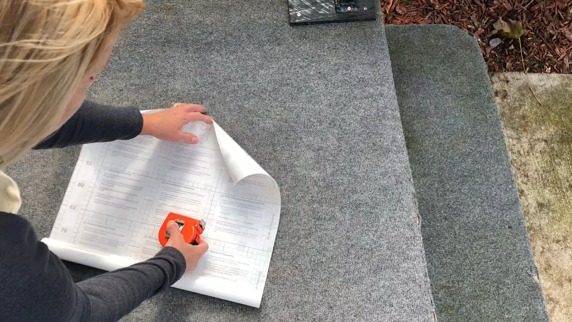 woman measuring out the privacy paper for window