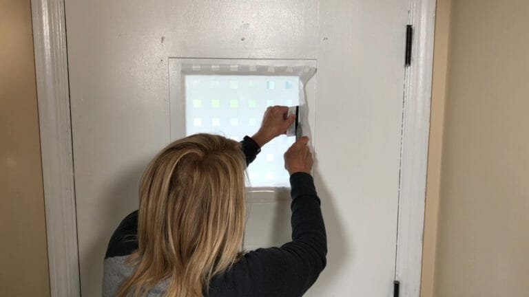 woman using a credit card to assure a smooth edge to privacy film