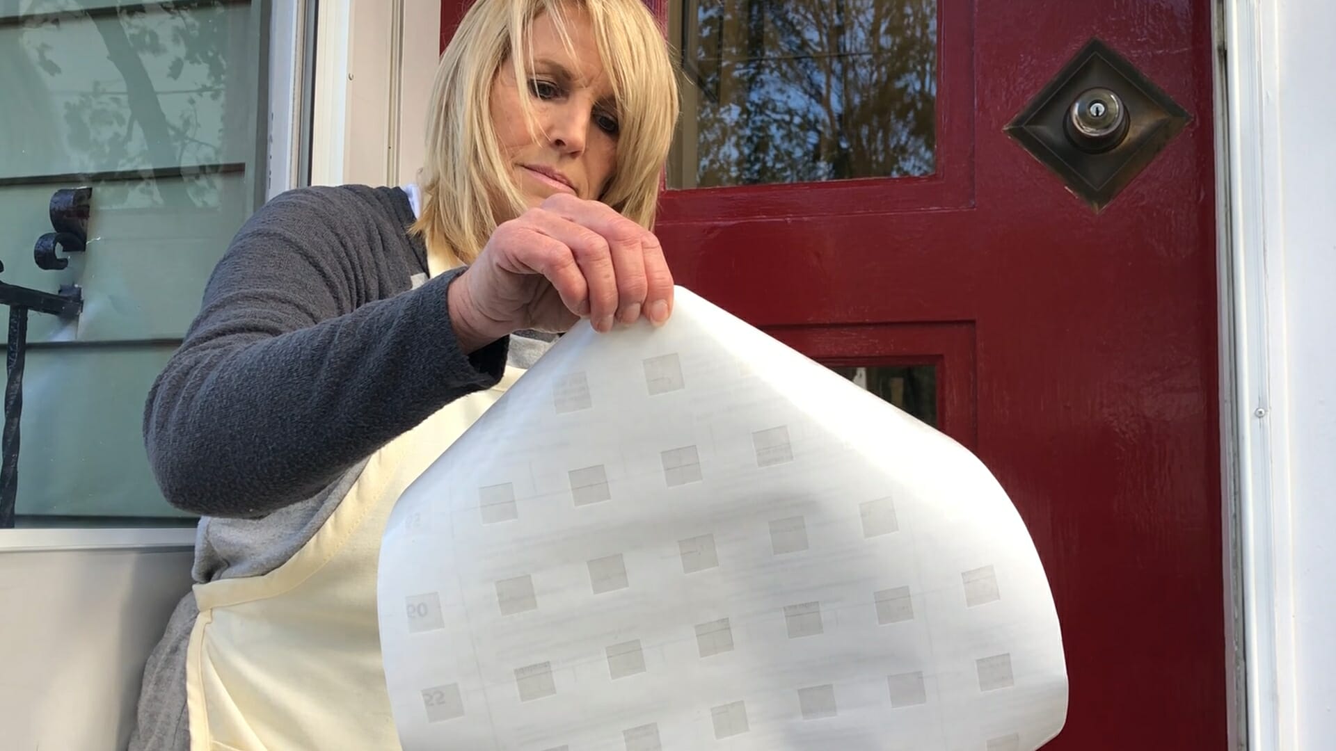 woman unrolling privacy material for window