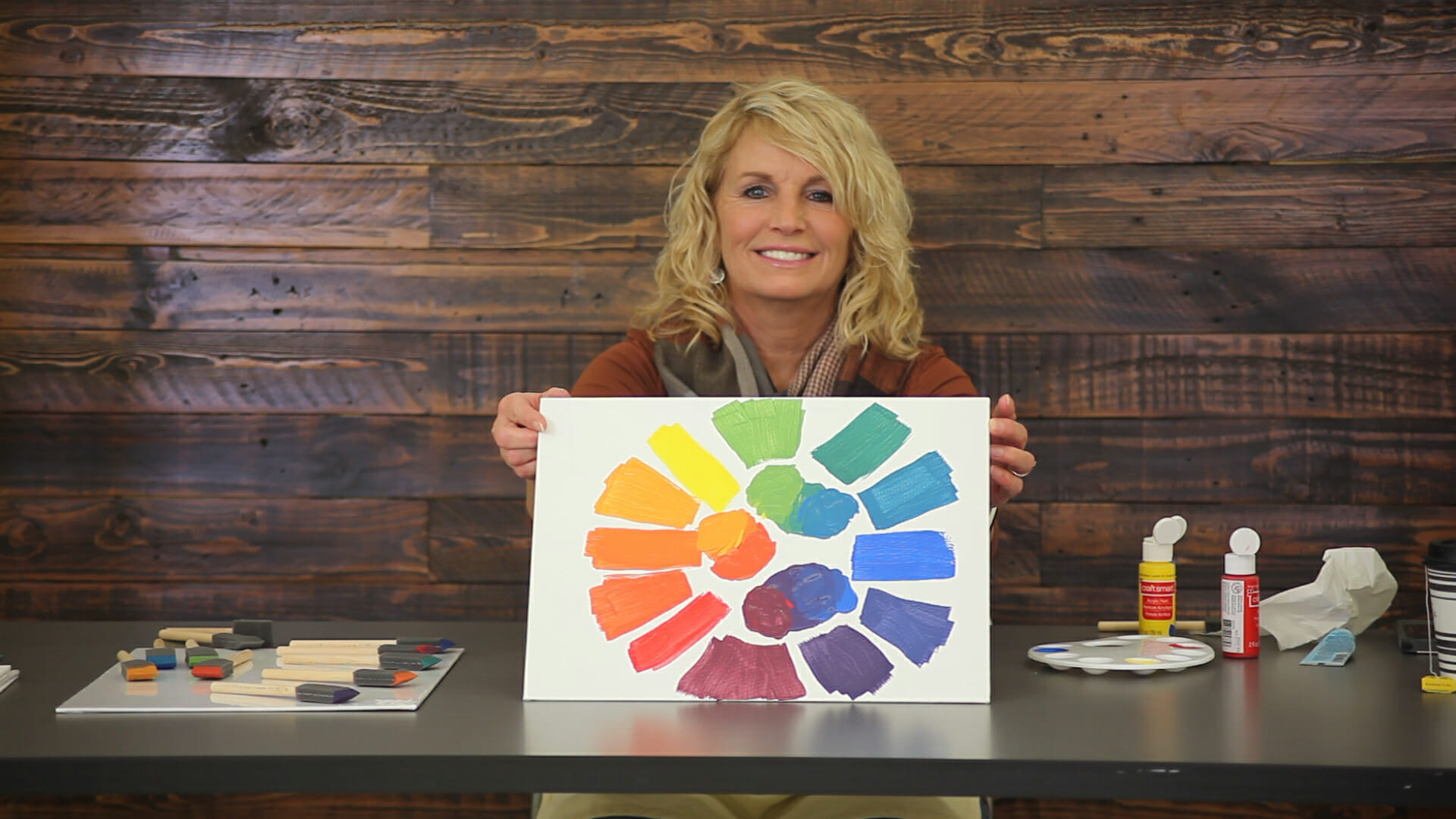 woman holding canvas of all rainbow colors
