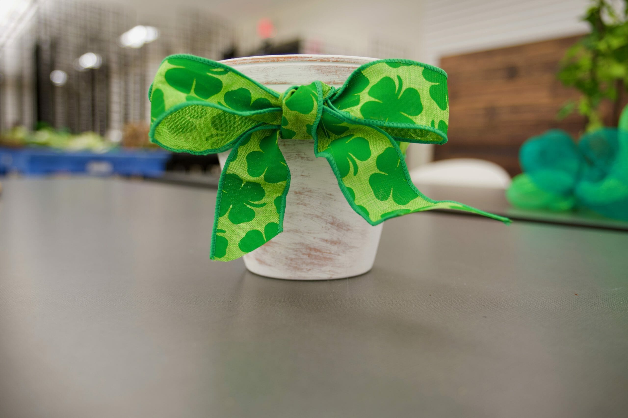 white painted flower pot with green shamrock bow