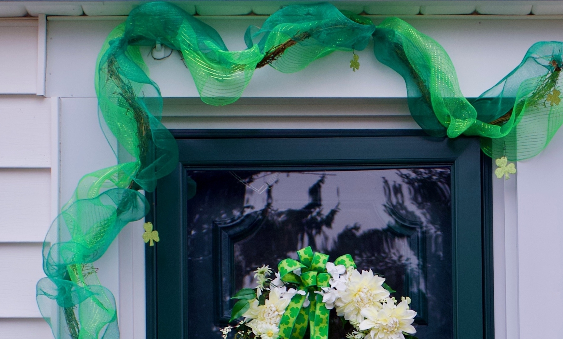 door with green garland and door wreath with St. Patrick's Day décor