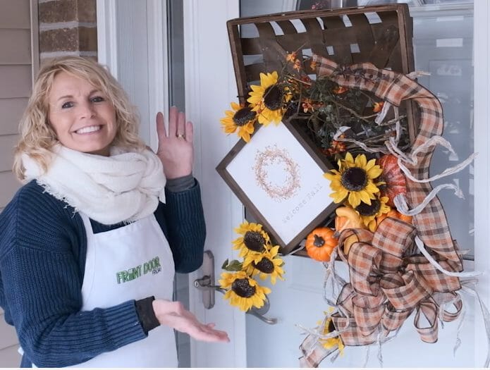 woman with basket wreath with sunflowers gourds and fall décor