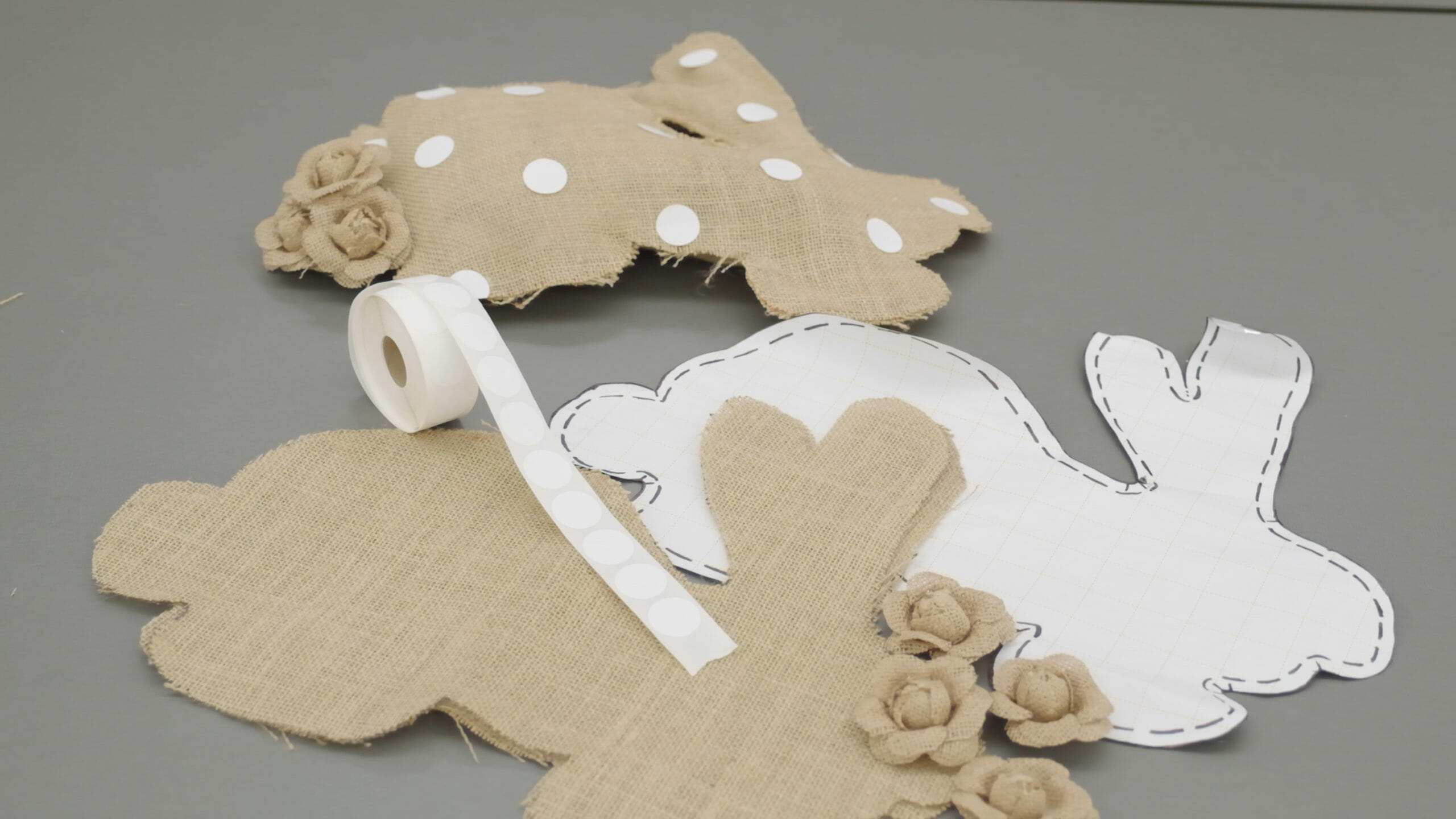 A rabbit pattern with stitching lines, cut burlap pieces and a stitched rabbit with a burlap flowers tail and white dots.