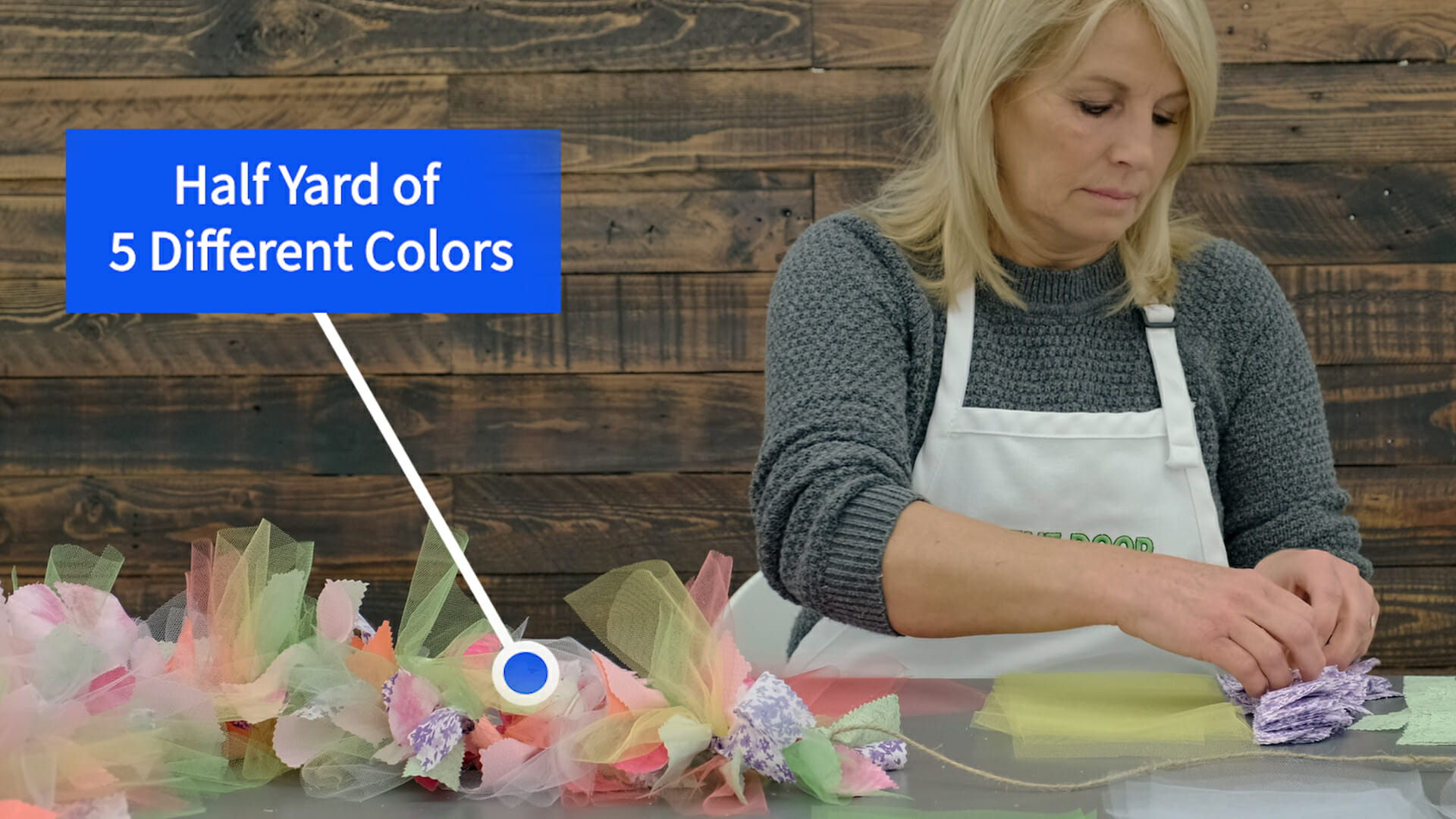 Half Yard of 5 Different Colors – A woman assembling colorful squares of tulle and calico into bunches for a wreath.