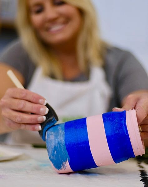 painting a pink and blue stripe Mason jar