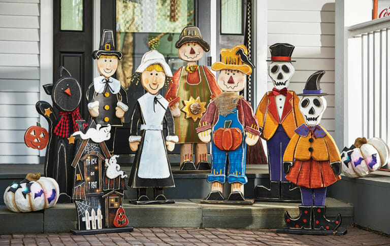 Outdoor decor of chunky wood cutouts on a porch, for Autumn, Halloween, and Thanksgiving.