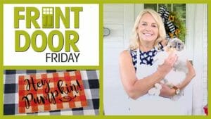Front Door Friday – Smiling woman in an apron holding a puppy – An orange check doormat with black Hey Pumpkin!