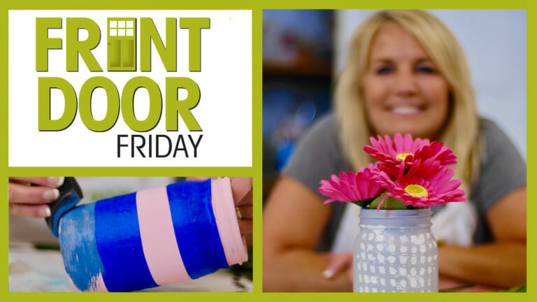 Front Door Friday – Smiling woman with a painted Mason jar filled with pink Gerbera daisies – Mason jar with blue stripes.